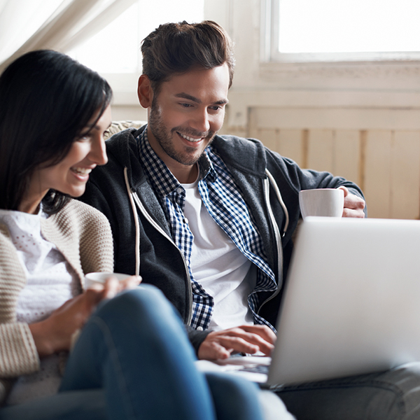 Image of young couple casually looking at laptop