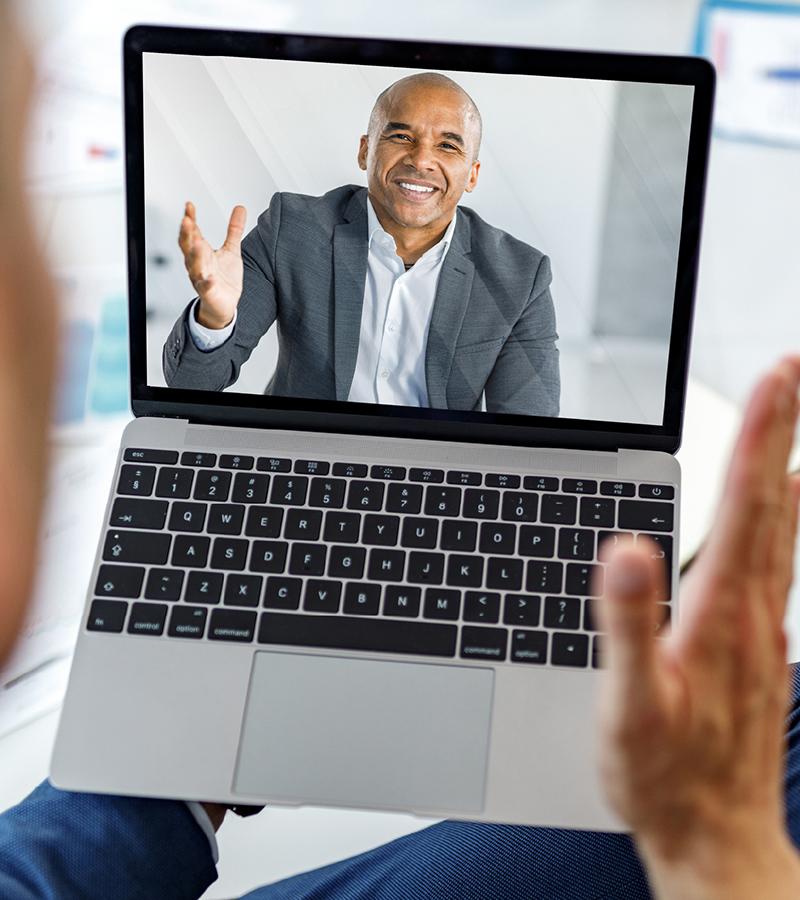 Man video chatting with f&I manager on laptop