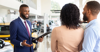 Car buyers talking with an F&I manager on the sales floor.