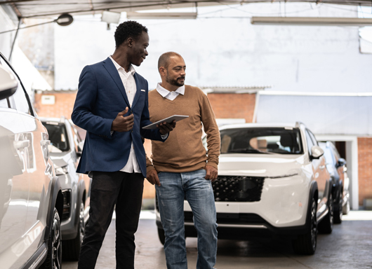 Dealership salesperson with customer in showroom