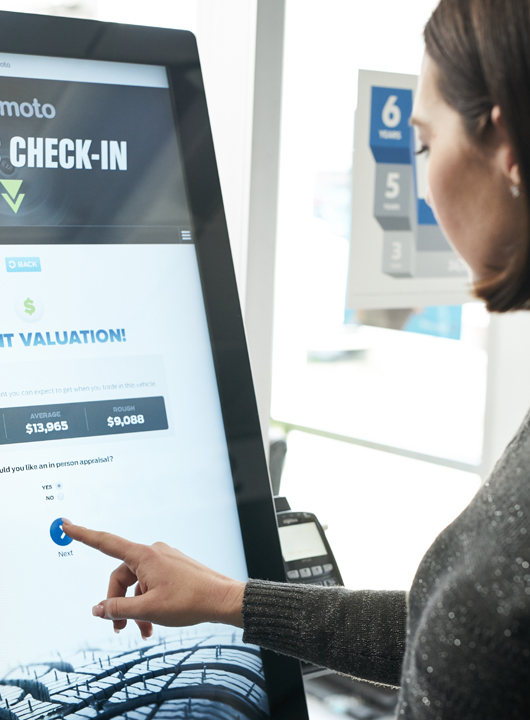 Woman using GoMoto kiosk