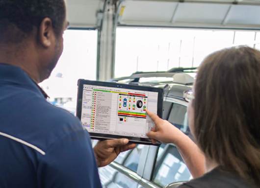 Customer pointing to Advanced Service software on tablet held by service technician