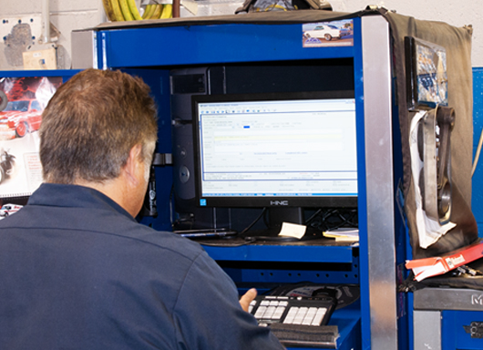 Dispatcher assigning ROs to technicians via computer