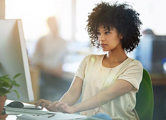 Woman in office working at computer on accounting electronic communications