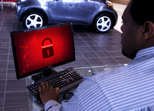 Dealership employee opening his computer to a malware attack.