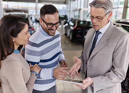 Dealership customers looking over deal paperwork.