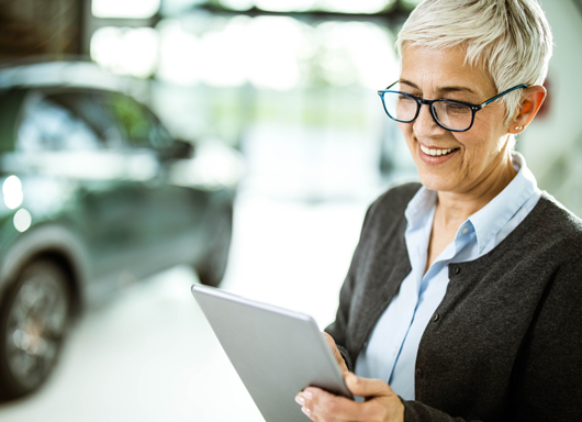 Salesperson working a car deal on tablet with Gubagoo