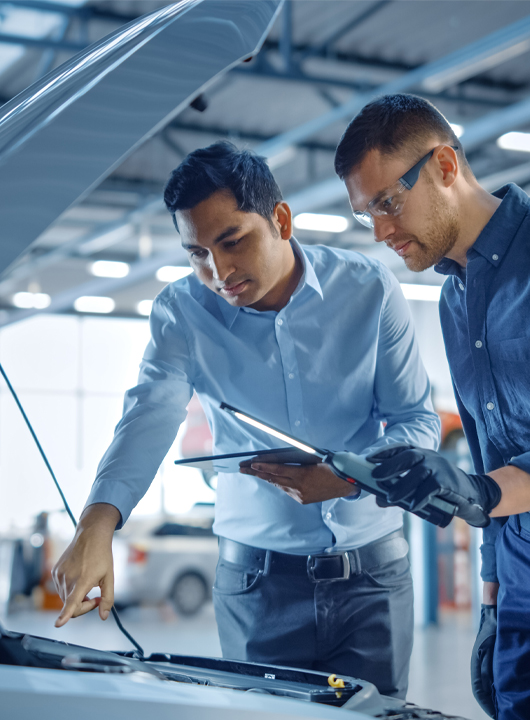A technician and an advisor looking over a car engine with tablets using ReconVision