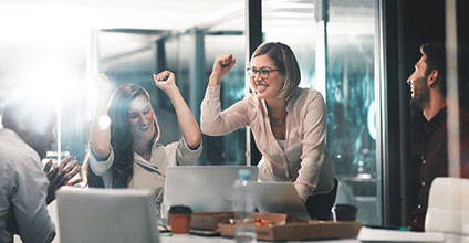 Coworkers around a conference table cheering.