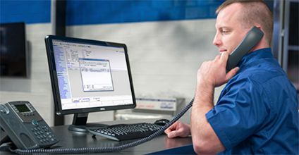 Man at computer on phone in service drive.