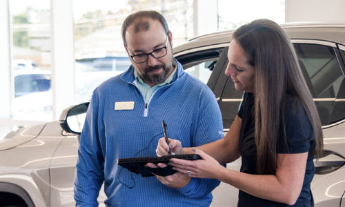 Two advisors completing the service write-up process on a tablet.