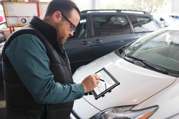 Employee appraising a vehicle with a tablet