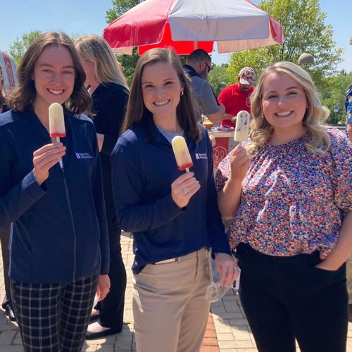 A group of three Reynolds employees enjoying a popsicle during a company employee appreciation day