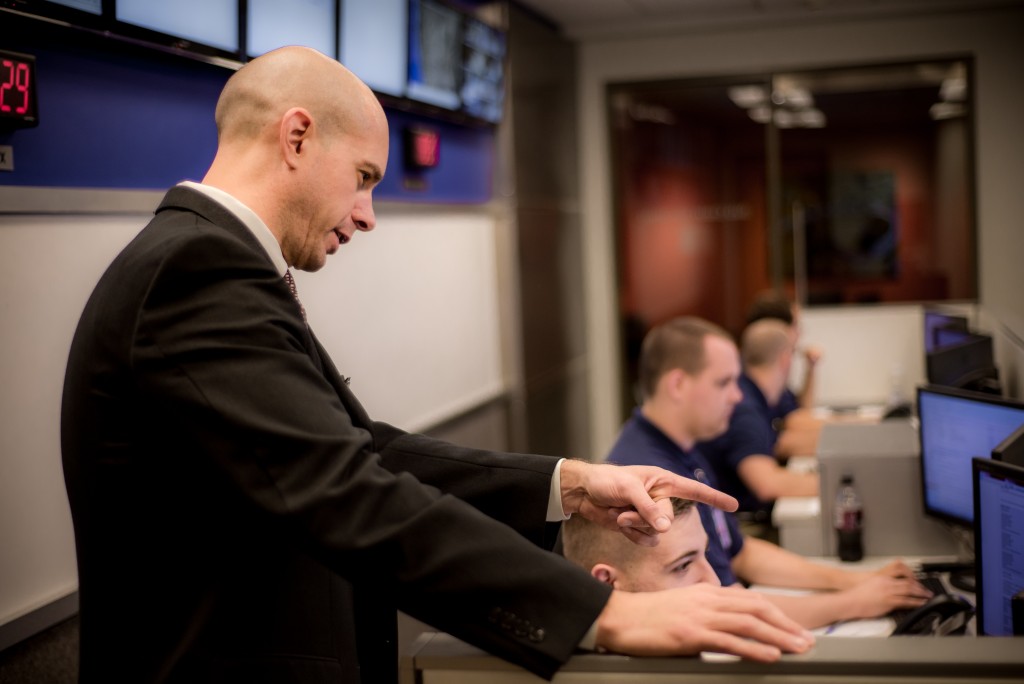 Clint Cargill, a bald man in a suit, instructing a class.