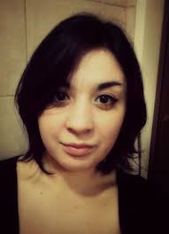 A dark-haired woman with a neutral expression