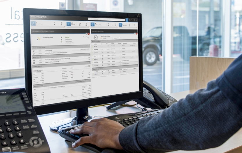 Service advisor looking at computer monitor with XtreamService screen