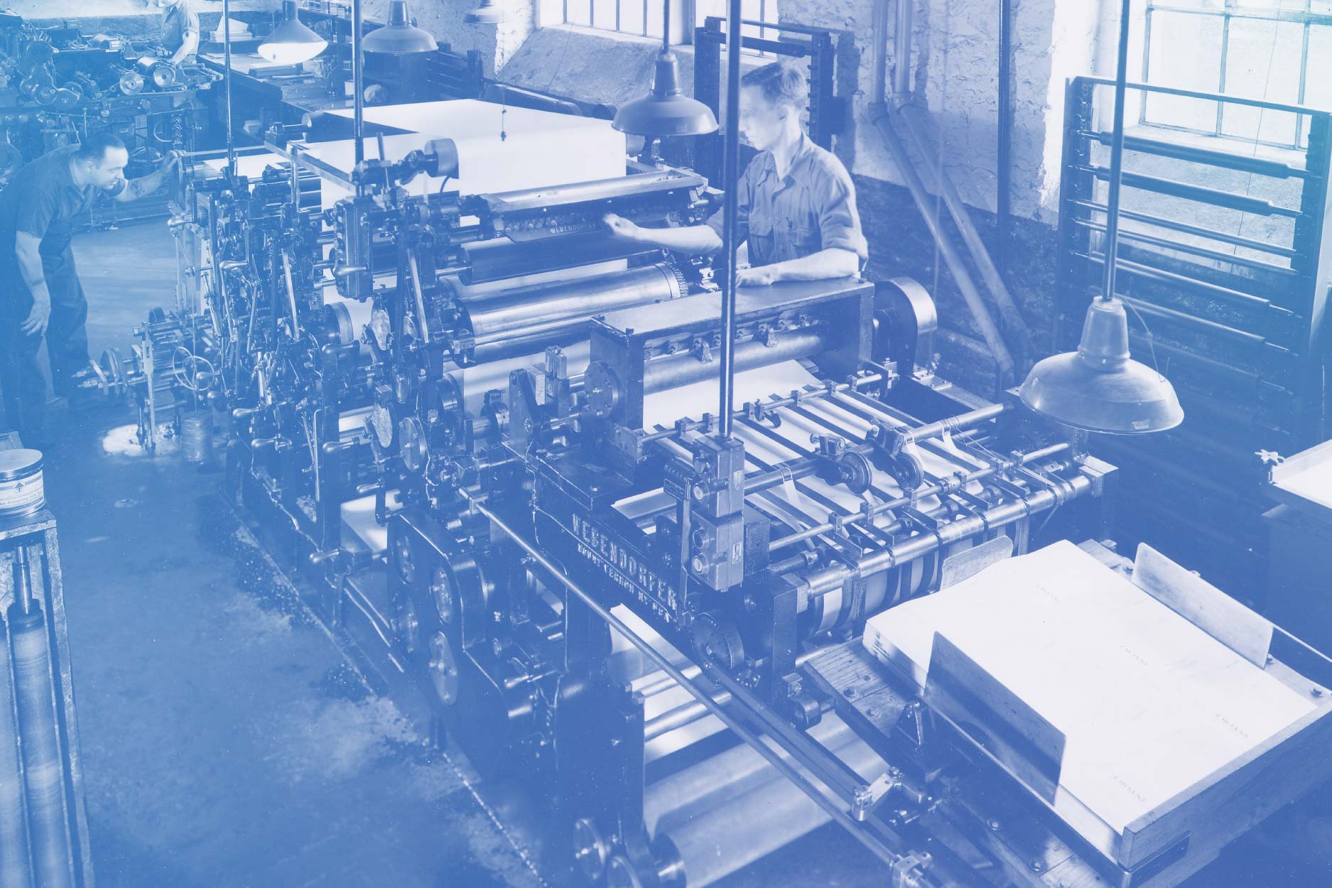 Photo with a blue overlay of Reynolds and Reynolds printing room in 1850