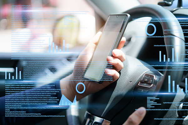 Person holding a phone in front of their steering wheel