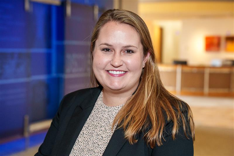Headshot of a woman with brown hair in a black blazer. 