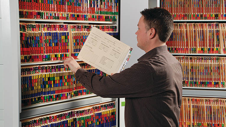 Man filing information using ColorFile Filing System.