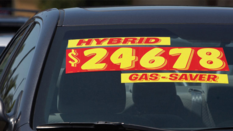 Car with a price sticker on the front windshield.
